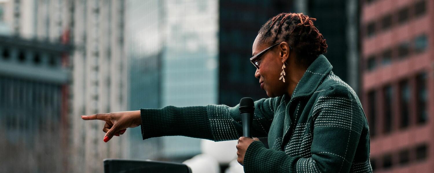 woman speaking to crowd. Photo by Colin Lloyd on Unsplash