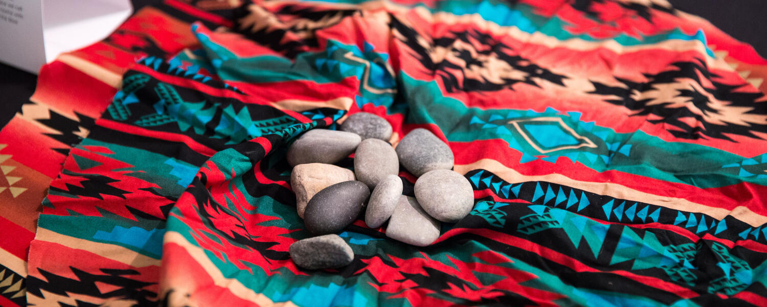 Rocks on top of Indigenous blanket