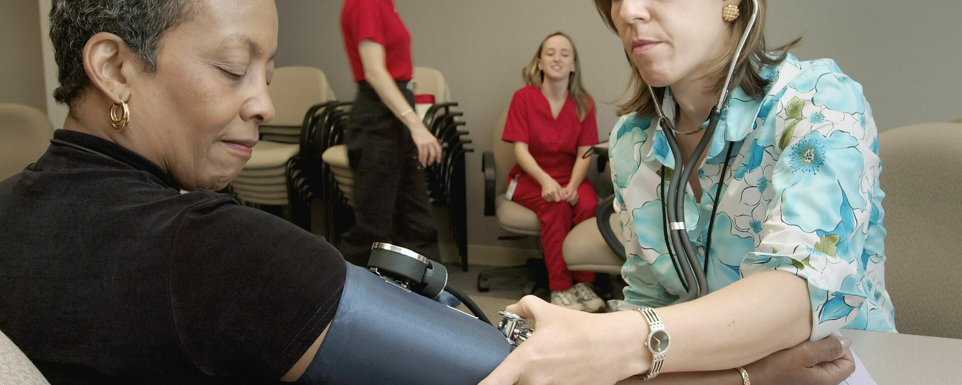 Woman having her blood pressure taken in a community centre.