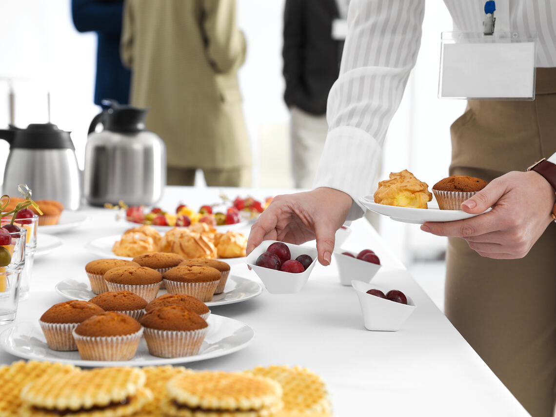 person grabbing food from breakfast buffet 