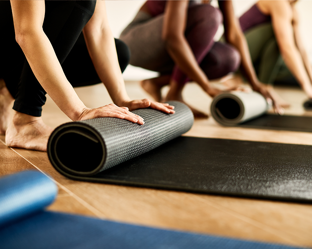 Yoga mats being rolled out at the start of a session.