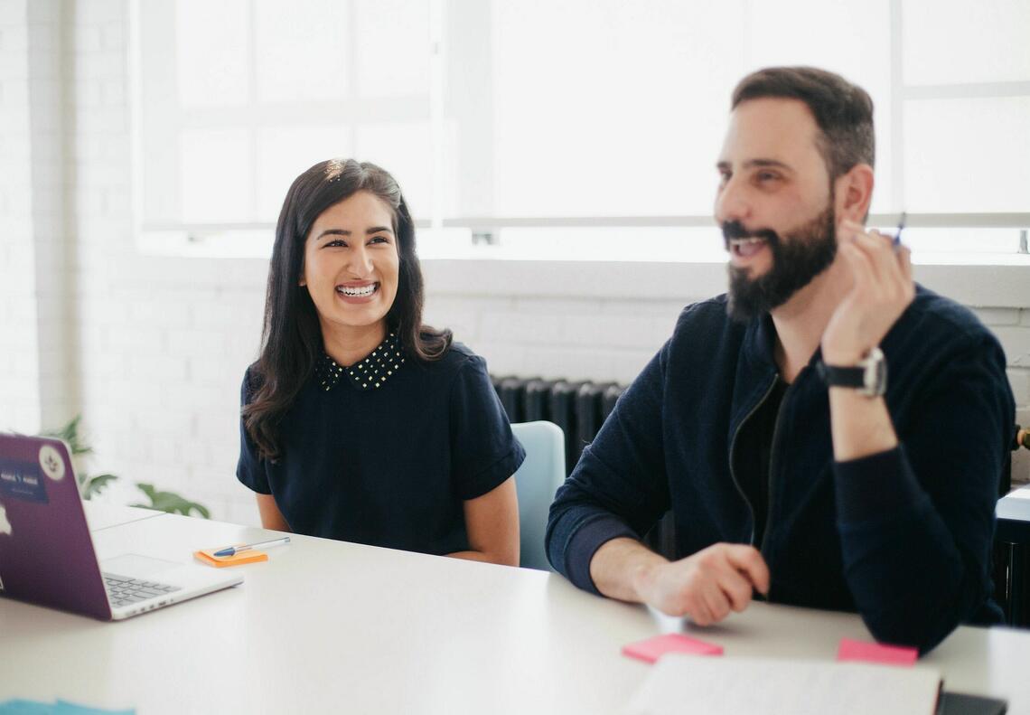 man and woman engaged in conversation at a desk