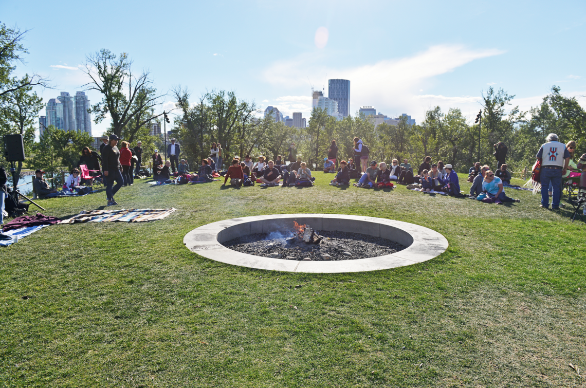 group gathered around an outdoor fire pit in the afternoon