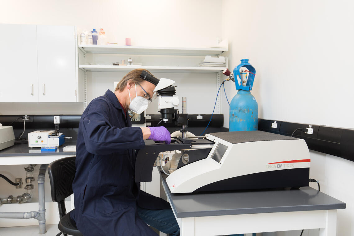 A person works in a lap with a piece of equipment