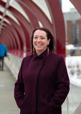Jennifer Markides, PhD, standing on the Peace Bridge in downtown Calgary.