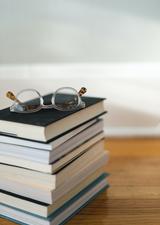 stack of books with glasses on top