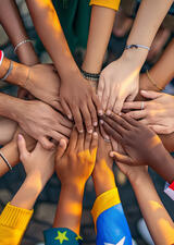people stacking their hands in the middle